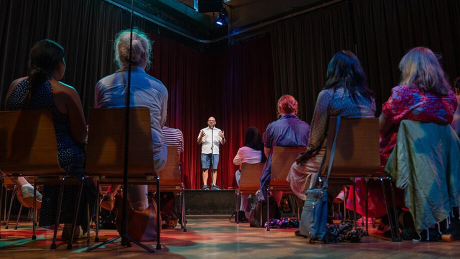 A photo of Paul Aflalo hosting a storytelling show at Soulpepper theatre.